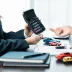 Closeup of people calculating an auto refinance with an extended warranty