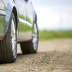 Close up of wheels and tires on a vehicle with a service contract sitting on a dirt road