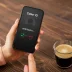 woman drinking coffee getting a warranty robocall on her iphone