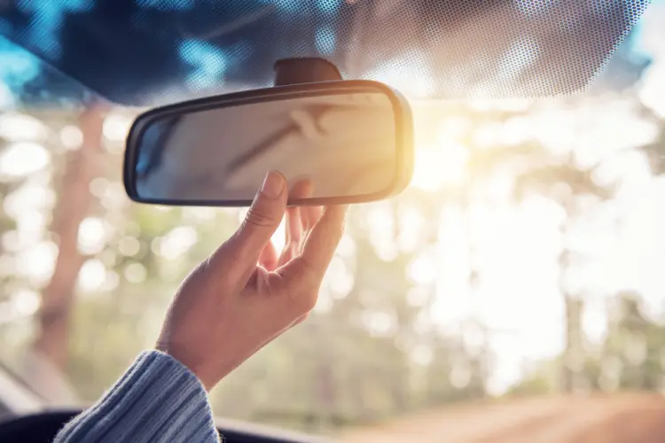 Car mirror being adjusted for safety
