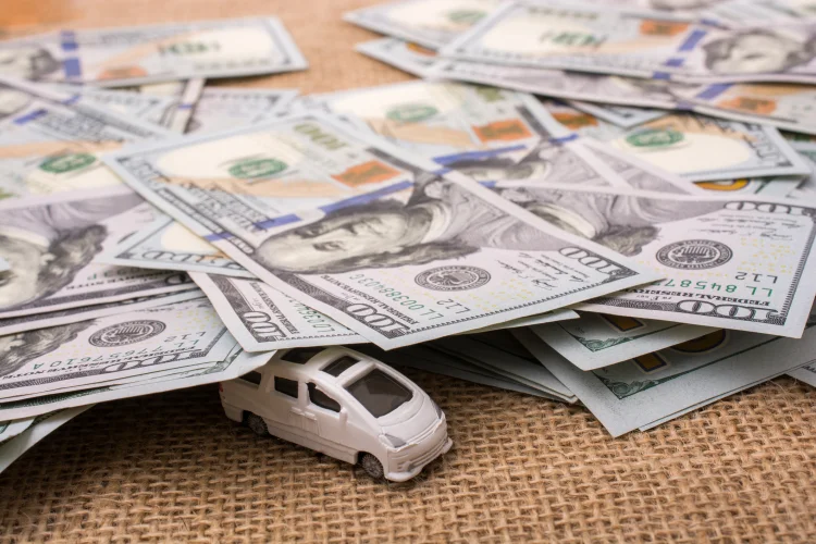 Model car covered by $100 US bills signifying auto warranty prices