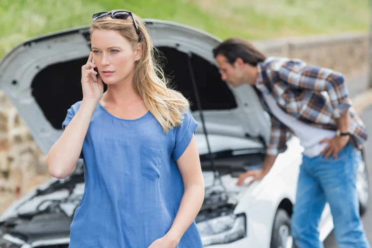 Couple experiencing a breakdown on the side of the highway