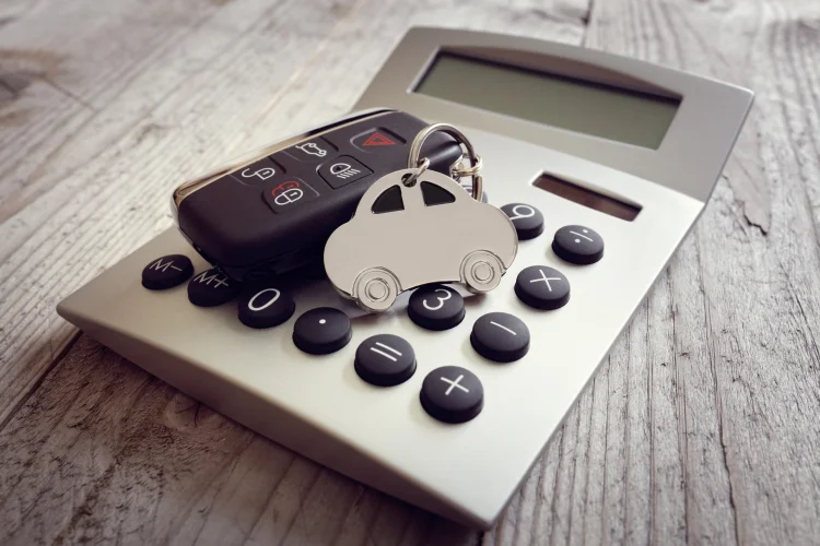 Keyring in the shape of a car on top of a calculator representing an extended warranty estimate