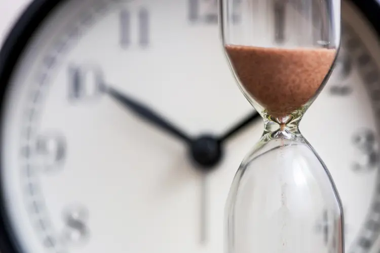 Clock and hourglass representing an extended warranty waiting period