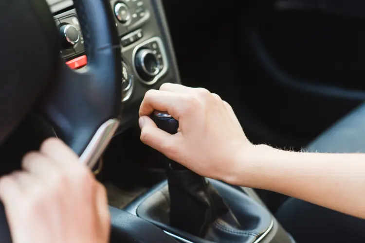 Hand on gear shift selector inside a car