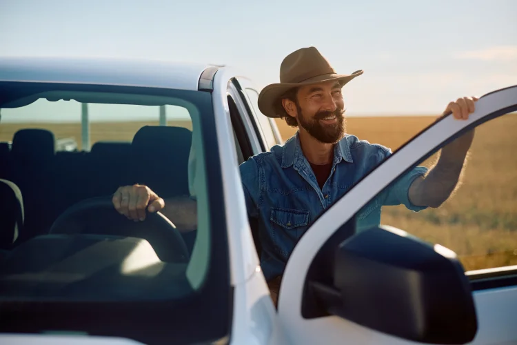 Happy farmer getting into his pick-up truck covered with an extended warranty