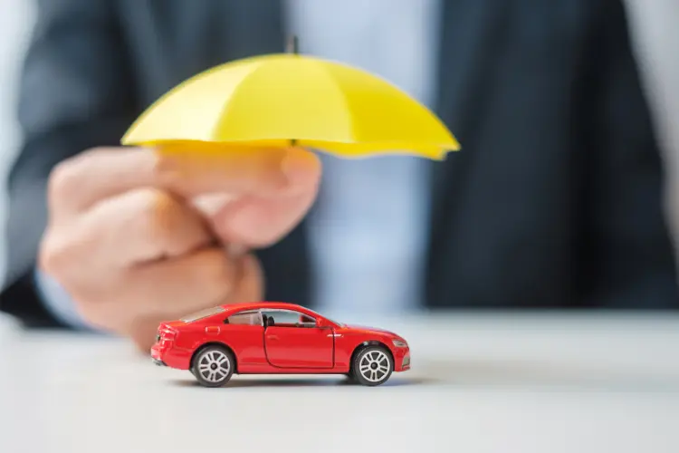tiny yellow umbrella over a red toy car