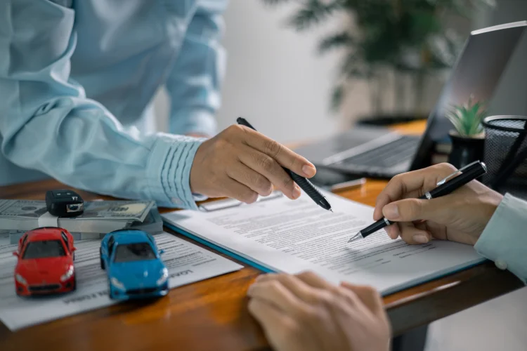 Customer signing a lease buyout loan contract that includes a warranty and taxes