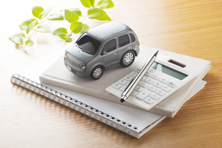 Grey toy car and a calculator on a desk