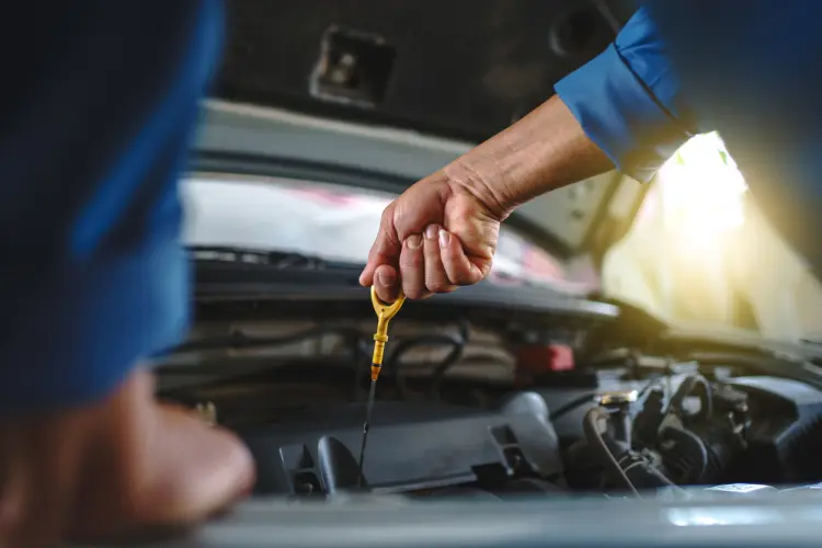 Mechanic pulling dipstick from car engine