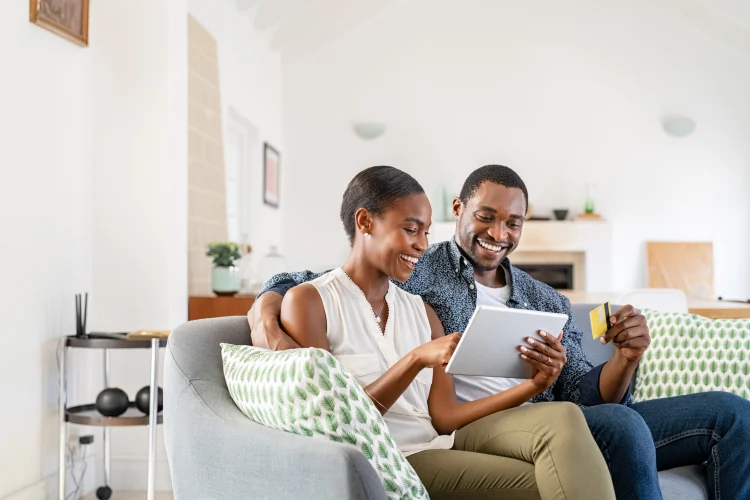young couple buying an online extended warranty on their sofa