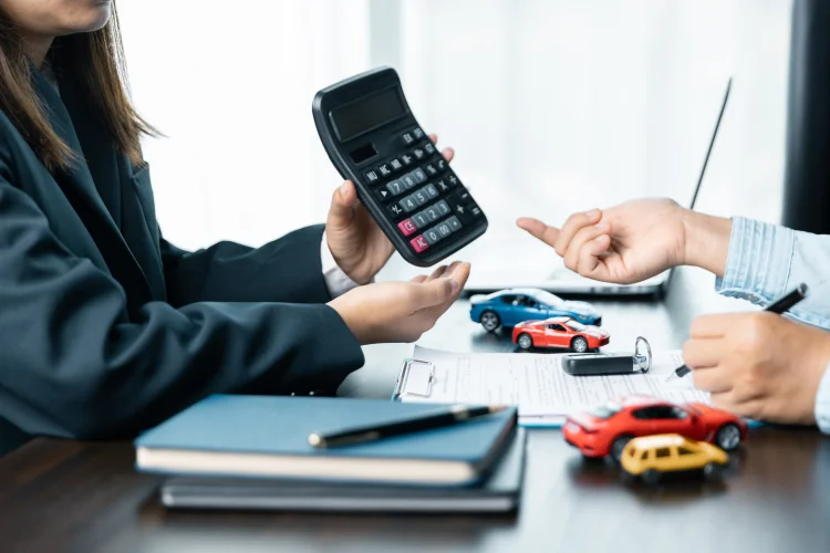 Closeup of people calculating an auto refinance with an extended warranty