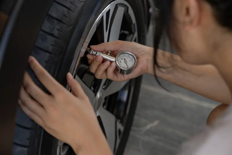 Woman checking air pressure in her tire
