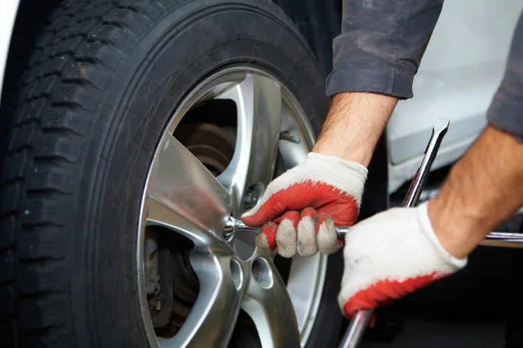 closeup of tire being changed on a silver vehicle