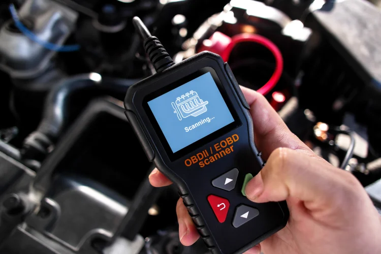 OBDII Scanner in use under the hood by auto mechanic for reading fault code of the car engine system