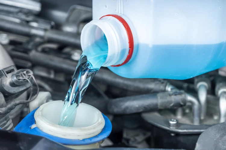 Closeup of a windshield washer fluid tank being filled