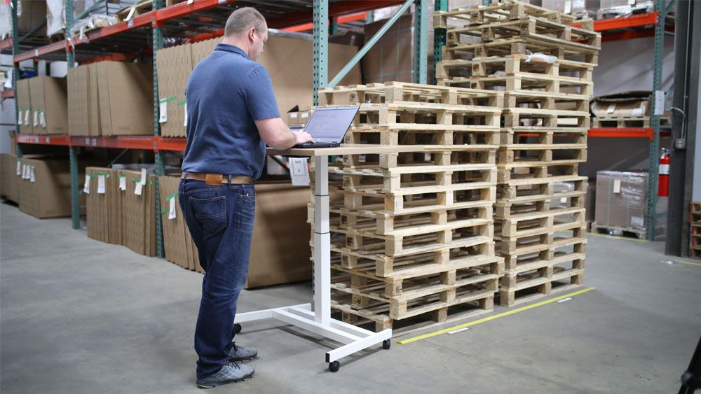 a man working on a computer in a warehouse