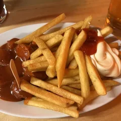 Currywurst with fries, ketchup and mayonnaise at Bergwolf in Munich