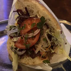 A döner in bread with tomato, onion, cabbage and parsley on a metal tray at Hasır in Berlin