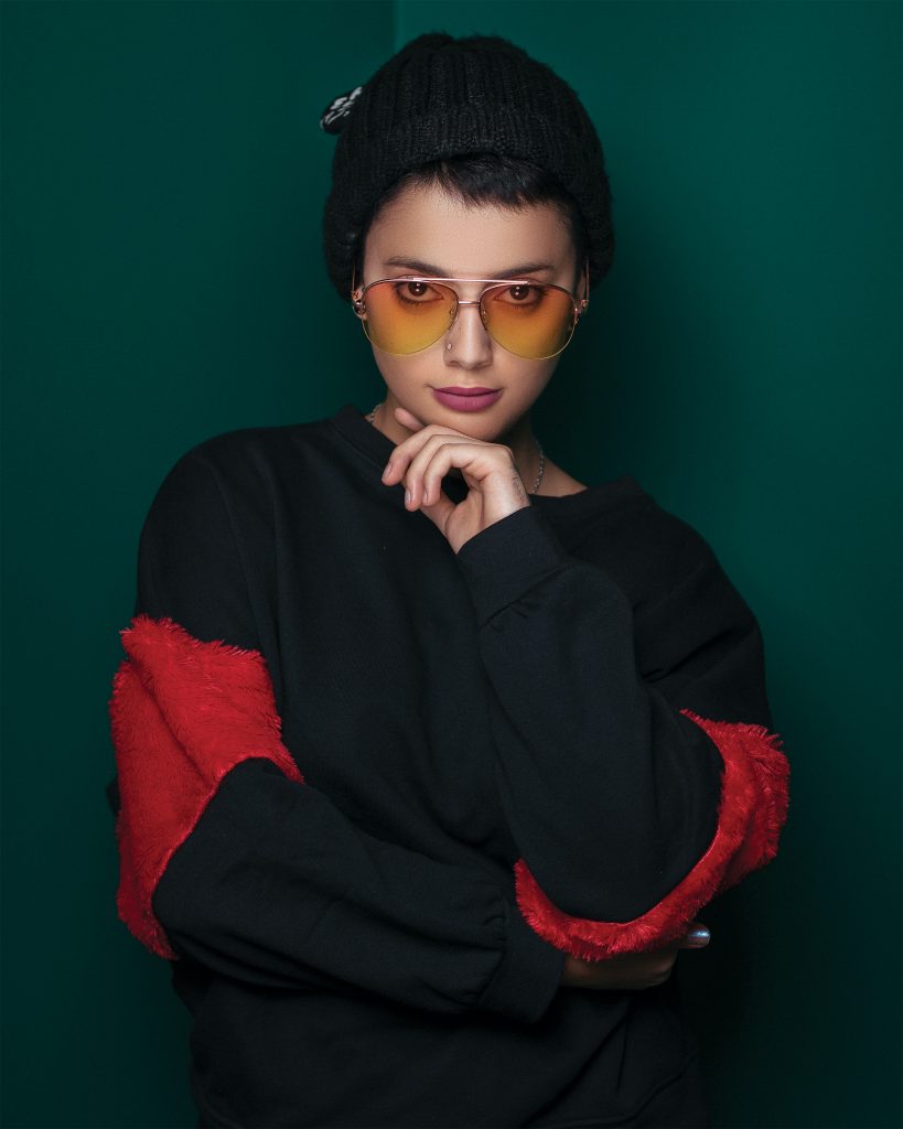 portrait photo of a woman wearing a beanie and sunglasses