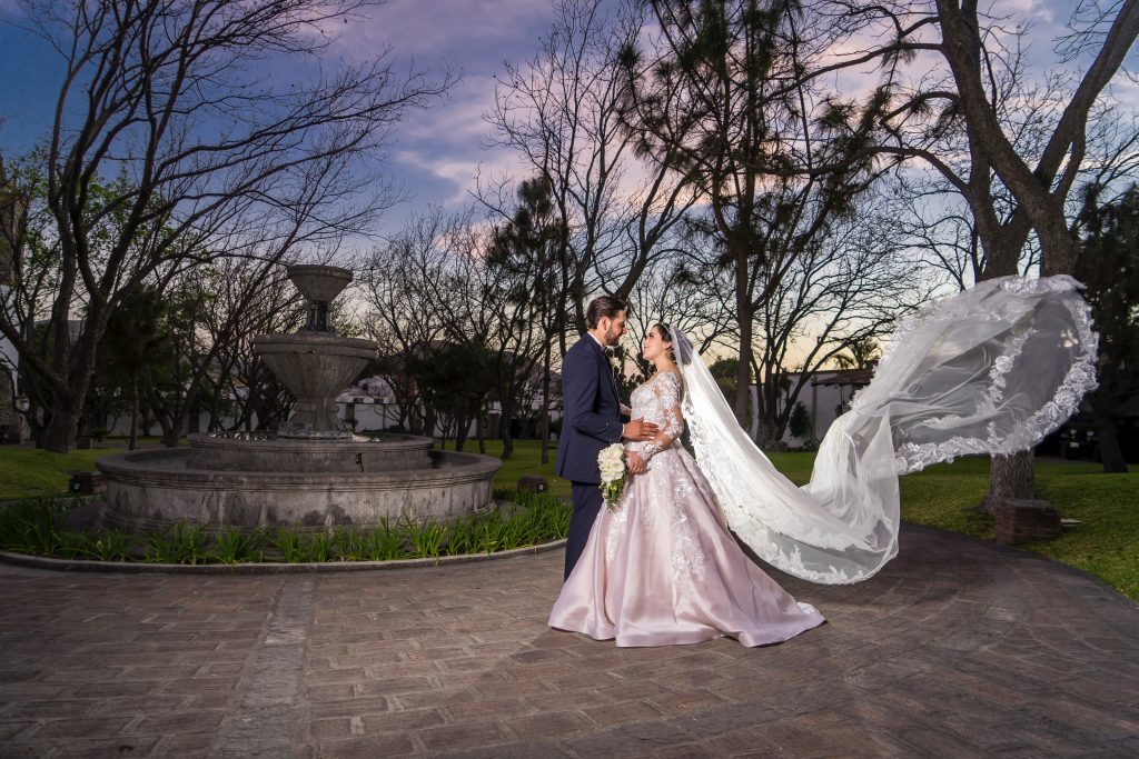 a wedding photo of a couple next to an old fountain