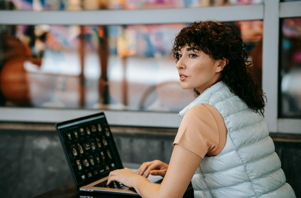 curly hair woman organizing photo library in her laptop