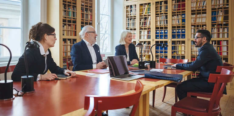 This picture shows a group of lawyers in a boardroom discussing how legal landing pages will generate more clients and revenue.