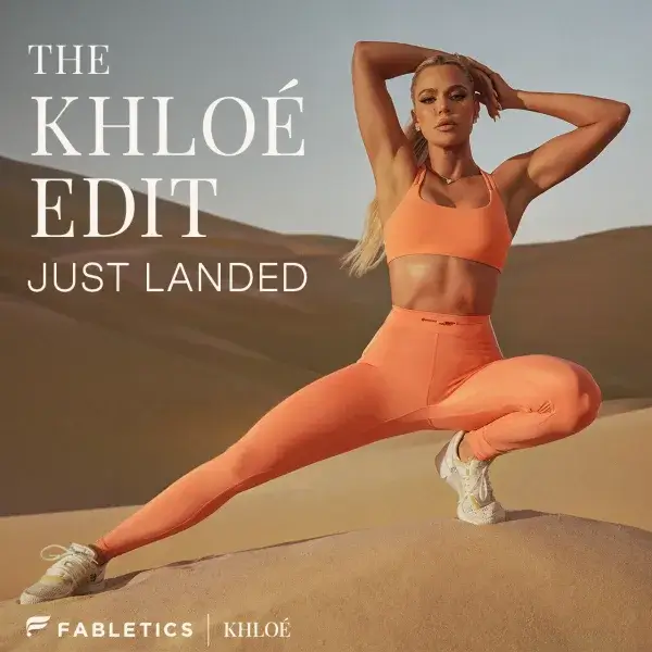 This is an advertisement for 'The Khloé Edit' by Fabletics. A woman in an orange sports bra and leggings strikes a dynamic pose in a desert landscape