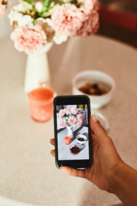 A Hand Taking Photos of the Food On The Table