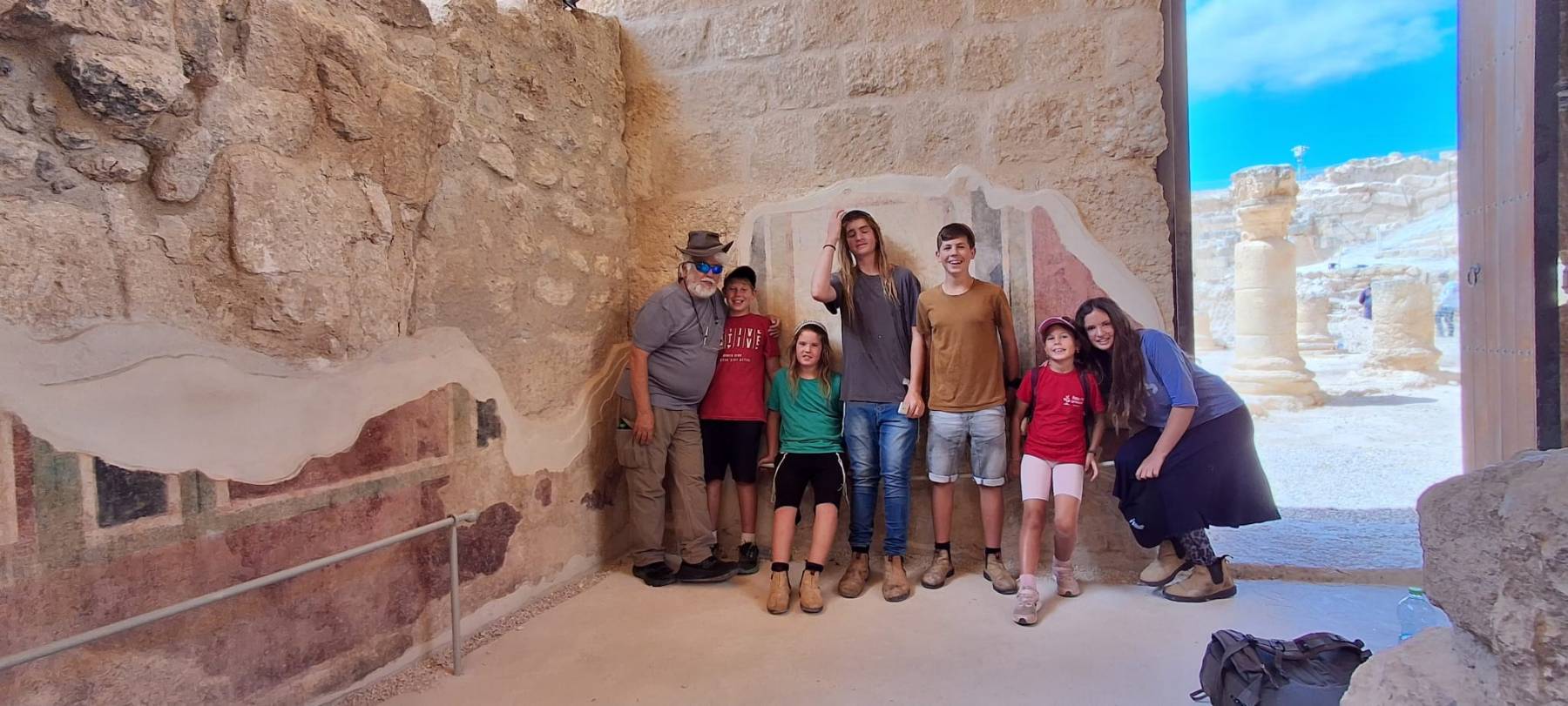 מורה הדרך נמרוד ויזנברג עם ילדים ובני נוער ממשפחה אחת, מול הפרסקאות המשוחזרות בהרודיון