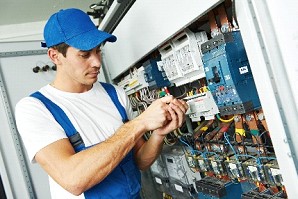 Electrician performing preventive maintenance inside an electrical panel