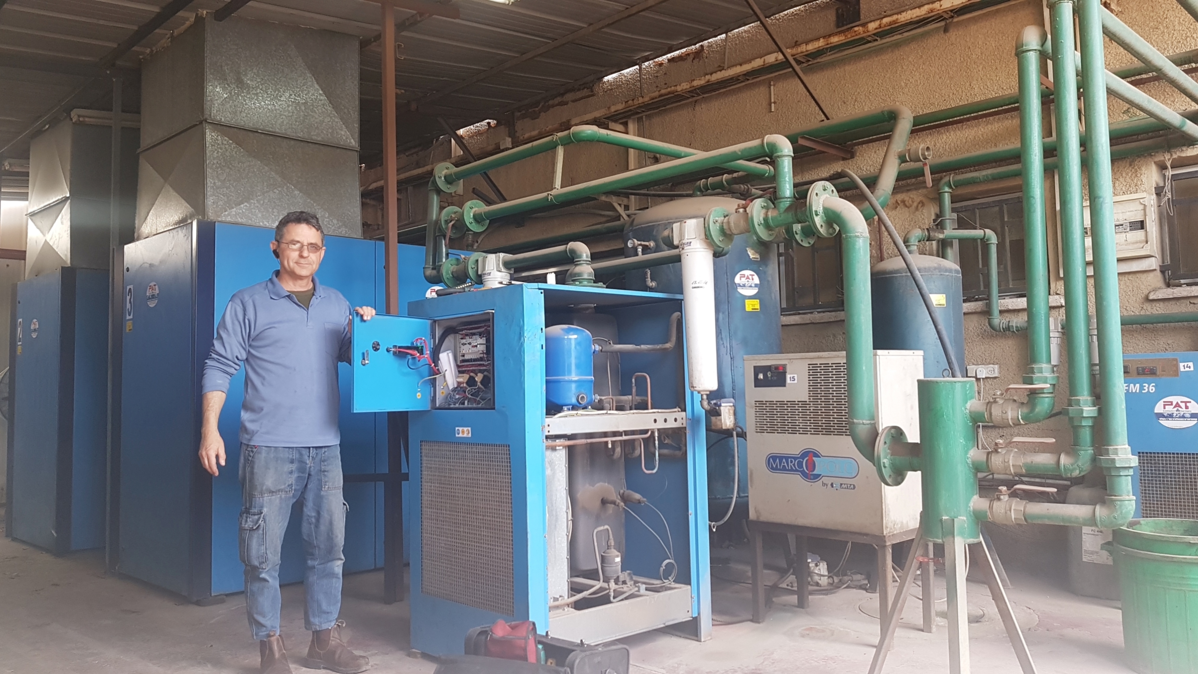 רוברט, טכנאי הקירור, ליד מערכת קירור תעשייתית