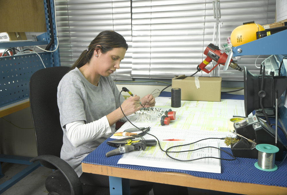 Technician assembling electrical components at a bench