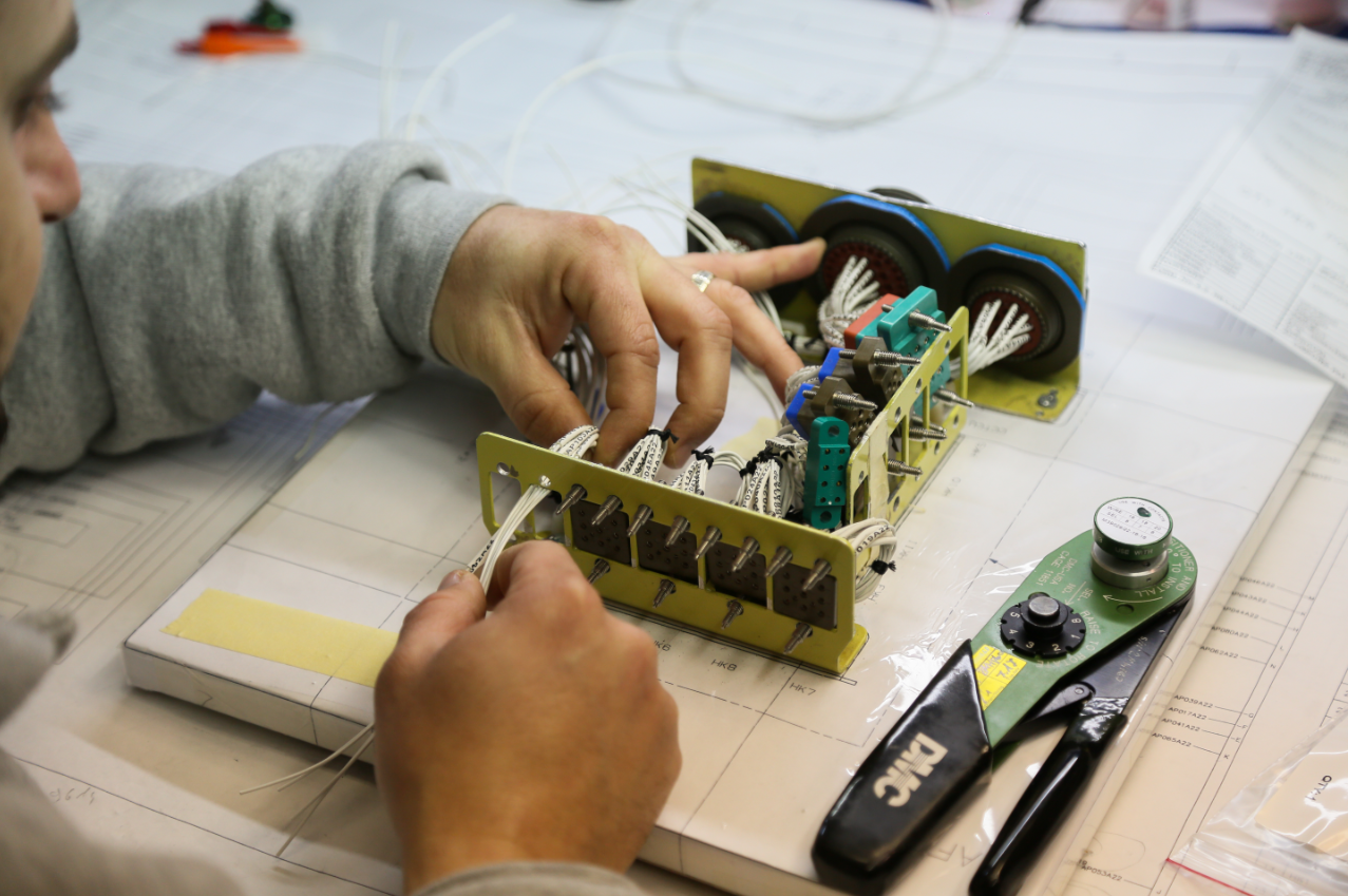 Technician wiring an electrical harness by hand