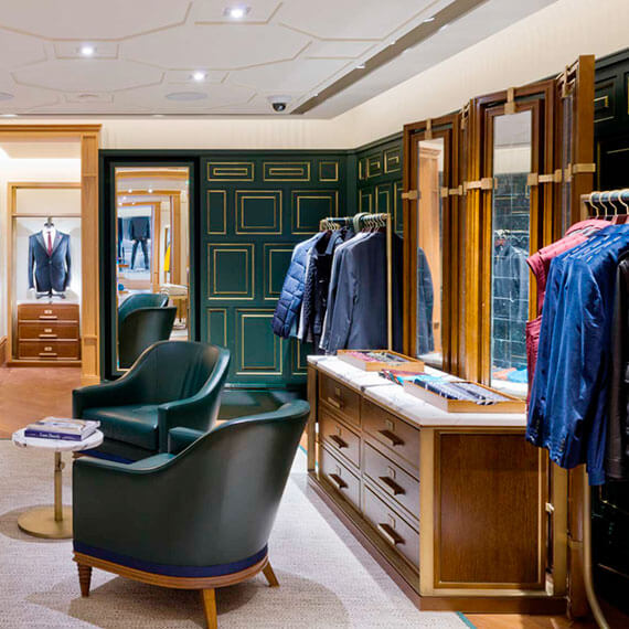 Kent and Curwen interior showing wooden display units and green leather chairs