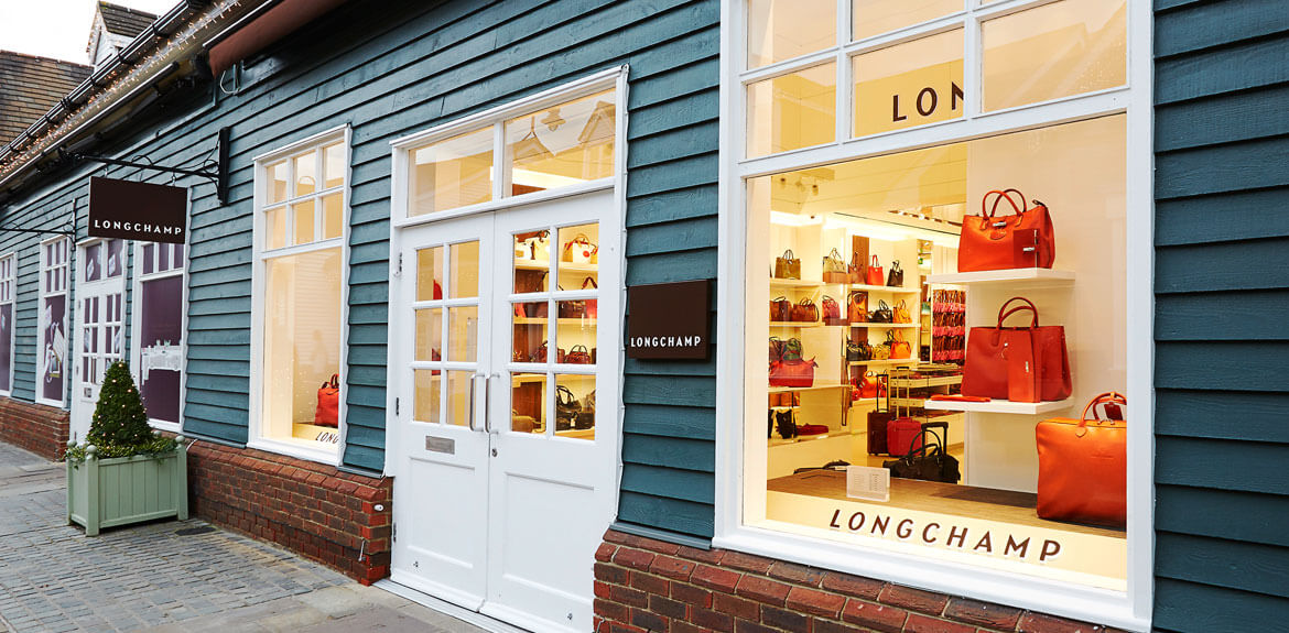 Longchamp exterior. The store has white window frames and a blue slated wooden wall