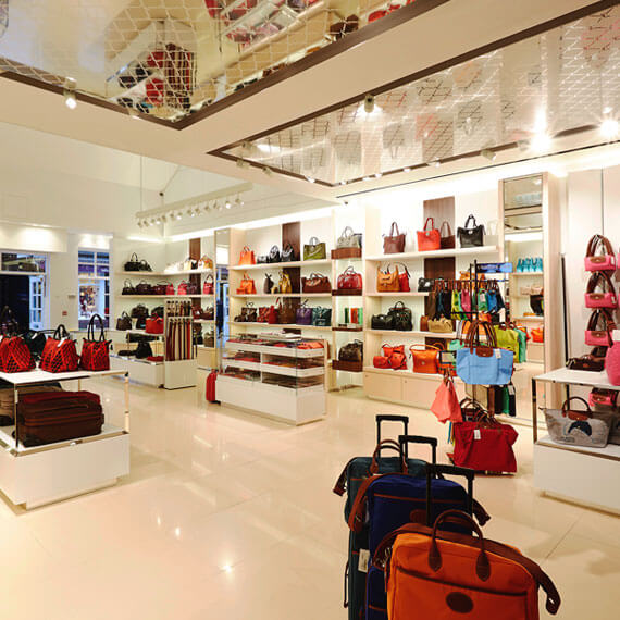 Longchamp interior showing full wall display of their bag selection