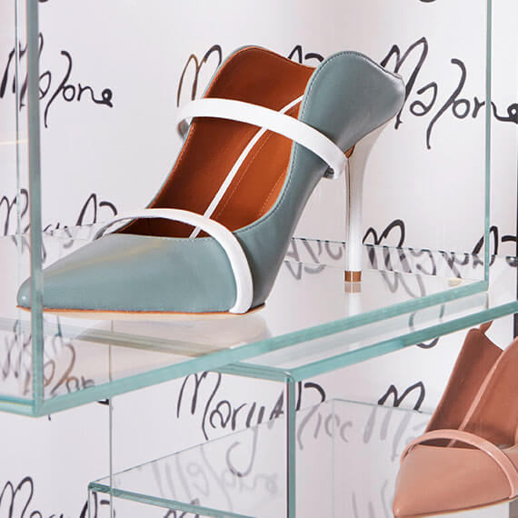 Close-up of glass shoe display boxes. showing light blue and white high heels