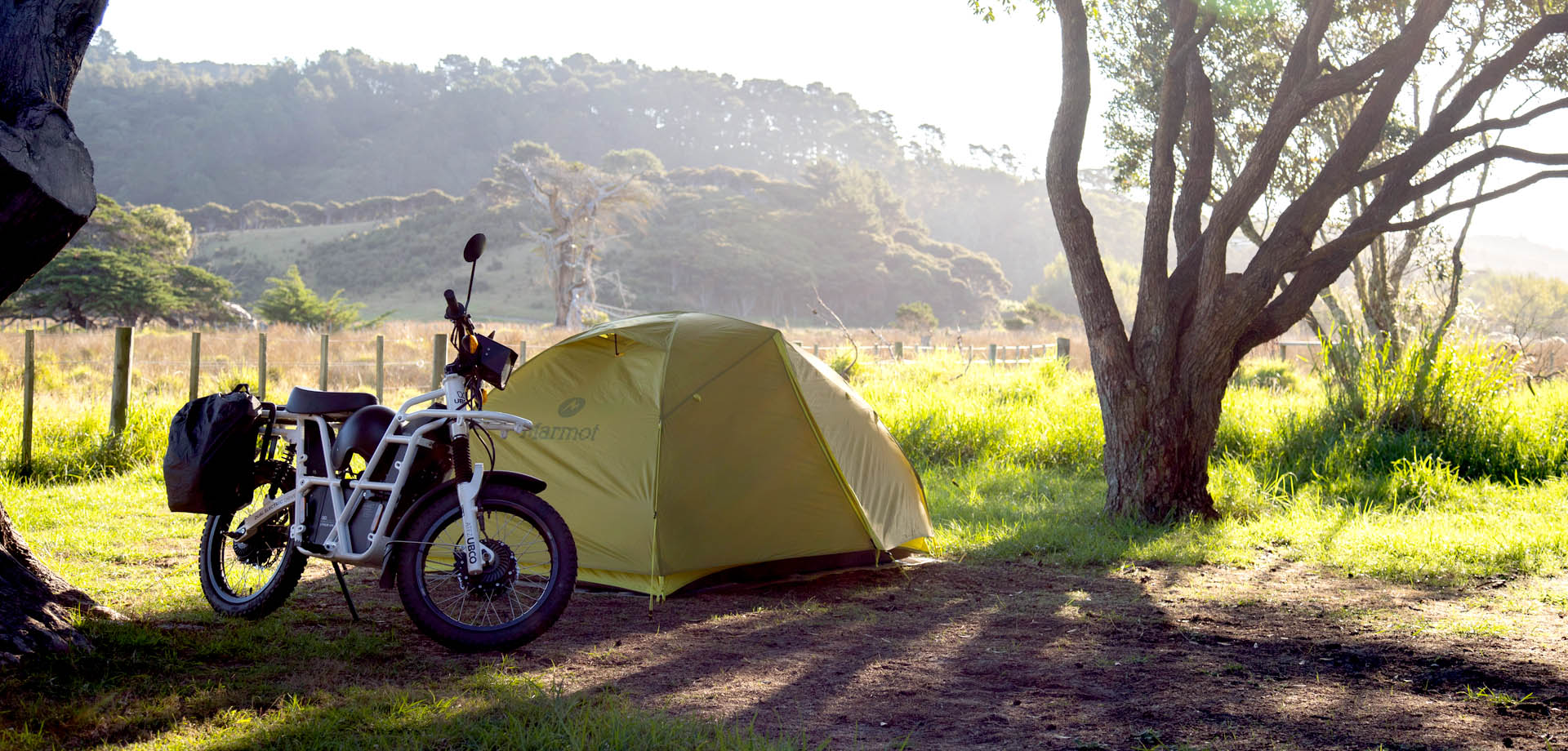 Two riders cruising a gravel road on Great Barrier Island