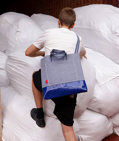 Een be the fibre tas gedragen over balen ingezameld textiel