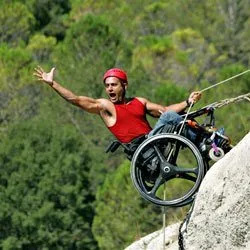 Dror Cohen rock climbing in a wheelchair