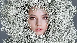 Tête d'une belle jeune fille entouré de fleurs.