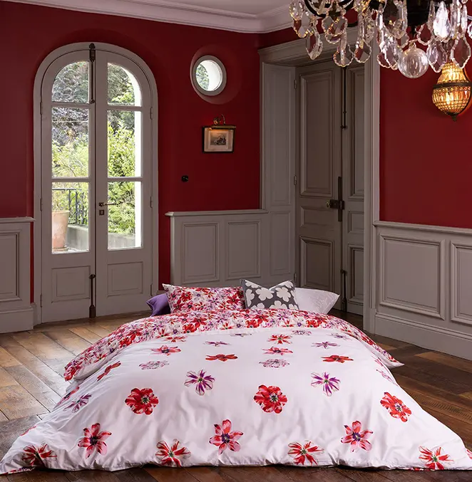 Parure de lit, déclinée du rouge au fuchsia, avec des nuances de rose et une pointe de vert céladon, elle illustre une palette joyeuse et lumineuse.