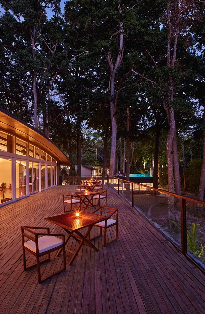 Dîner en soirée sur une terrasse romantique près de l’hôtel, entourée de nature et éclairée de bougies.
