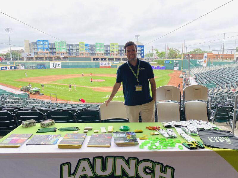 A general manager spending a Sunday morning promoting summer camp at a baseball game