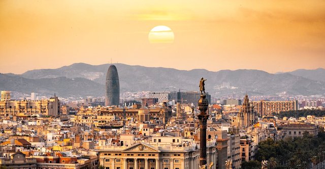 A stunning sunset view of the Barcelona skyline showcasing iconic landmarks and a warm, golden hour glow.