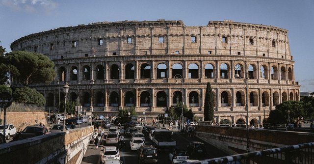 The Colosseum stands majestically amidst bustling Rome, an iconic remnant of ancient architecture.