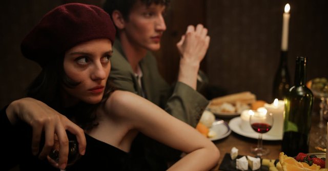 A romantic candlelit dinner with a couple enjoying a cozy evening. Parisian vibes and intimate setting.