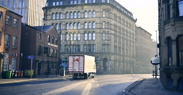 A quiet urban street scene with historic architecture in early morning light.
