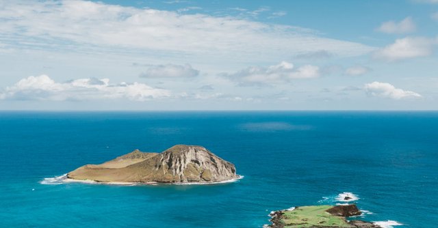 Stunning aerial view of Rabbit Island with vibrant turquoise waters and clear blue skies.
